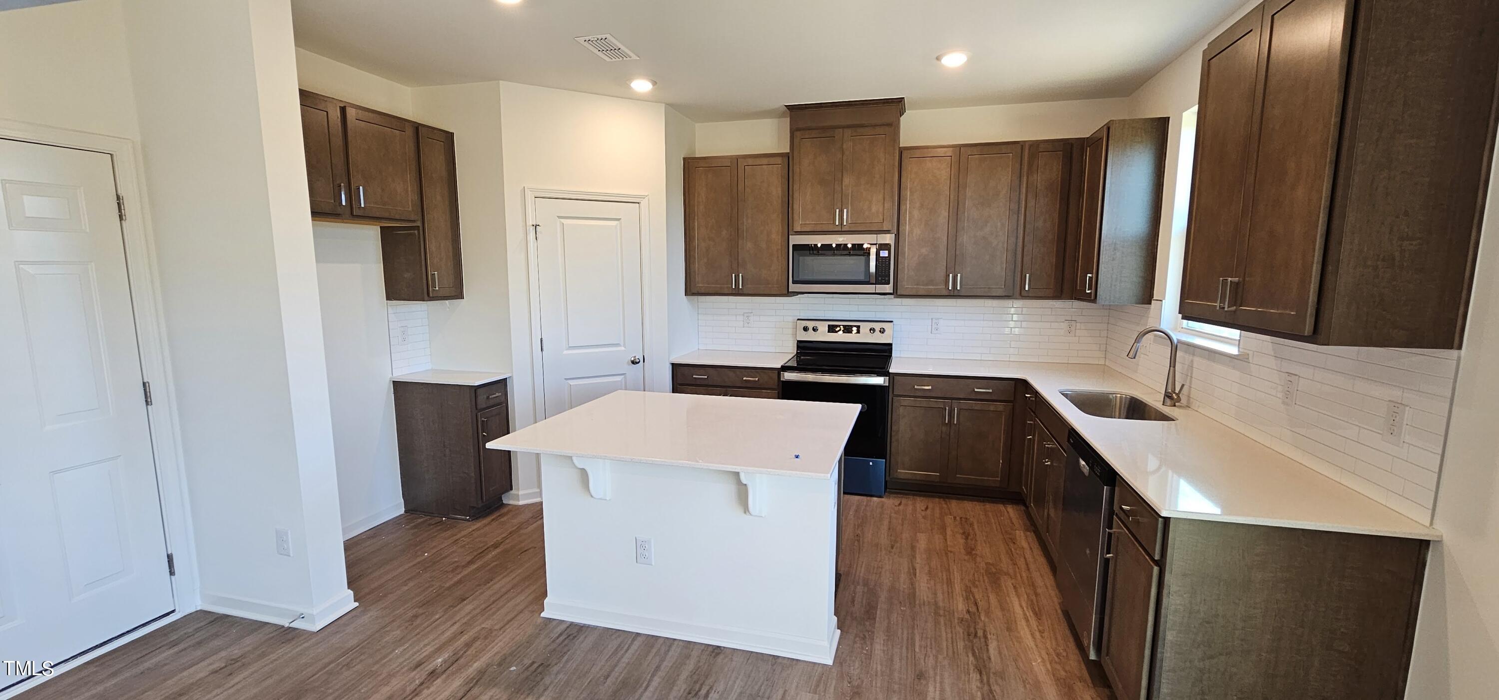 1409 Underbrush Drive Durham, NC 27703 - Photo 2 of 21 a kitchen with a sink a stove cabinets and wooden floor