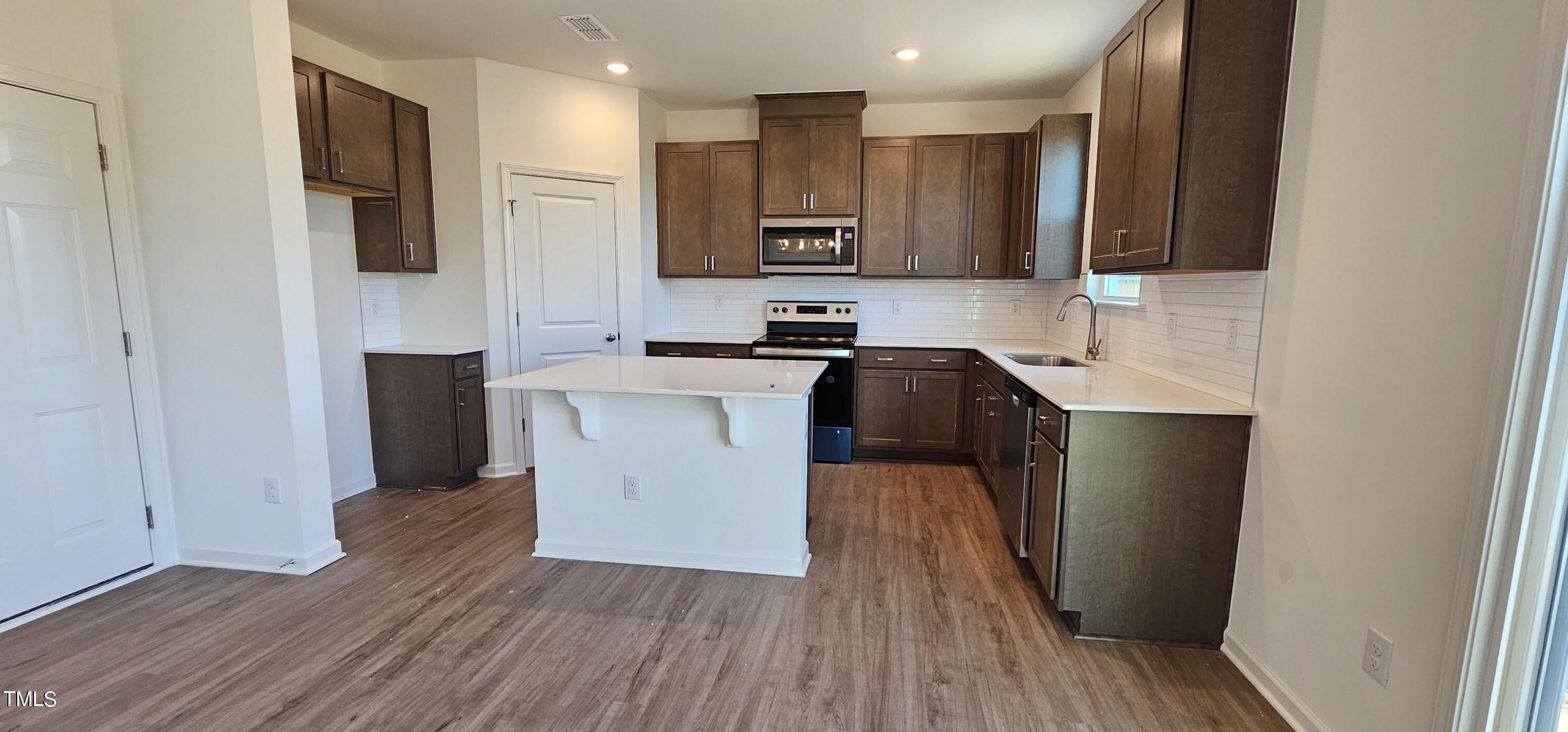 1409 Underbrush Drive Durham, NC 27703 - Photo 3 of 21 a kitchen with wooden floors and refrigerator