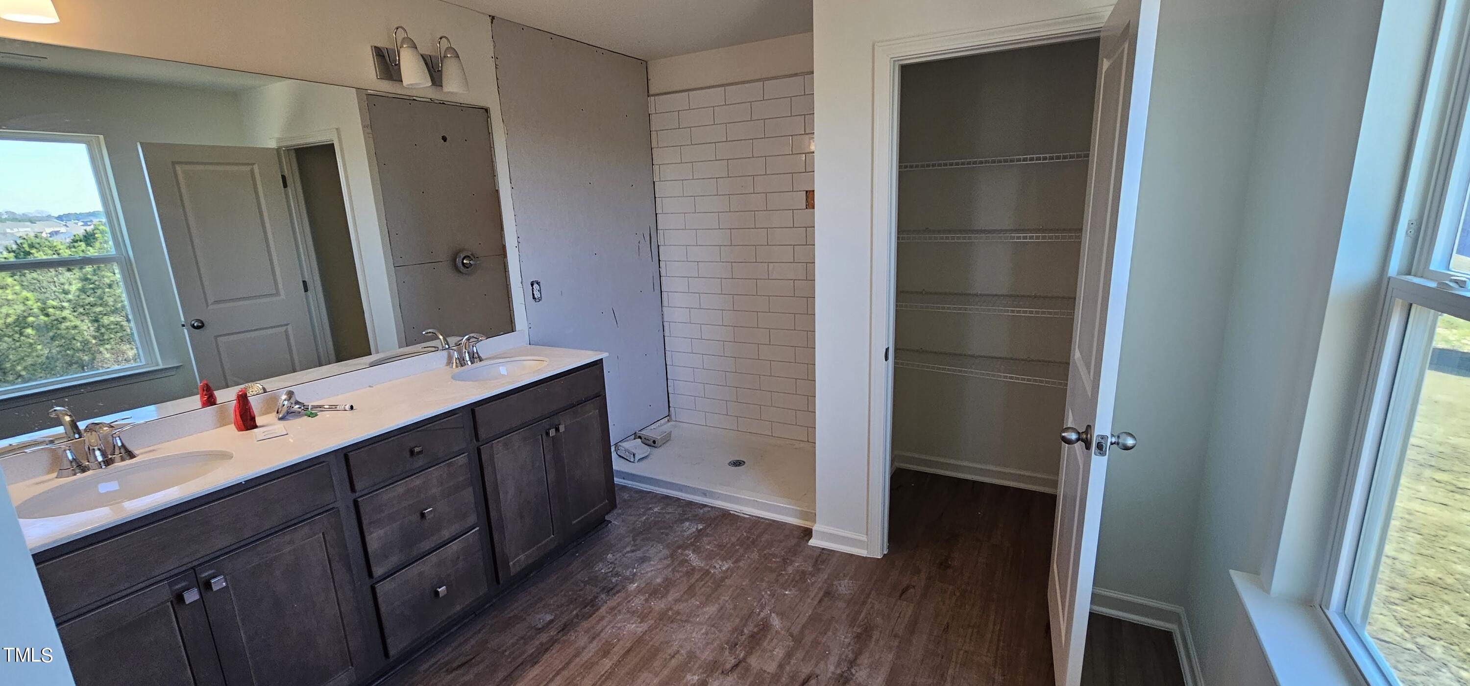 1409 Underbrush Drive Durham, NC 27703 - Photo 9 of 21 a bathroom with a double vanity sink a mirror and a shower