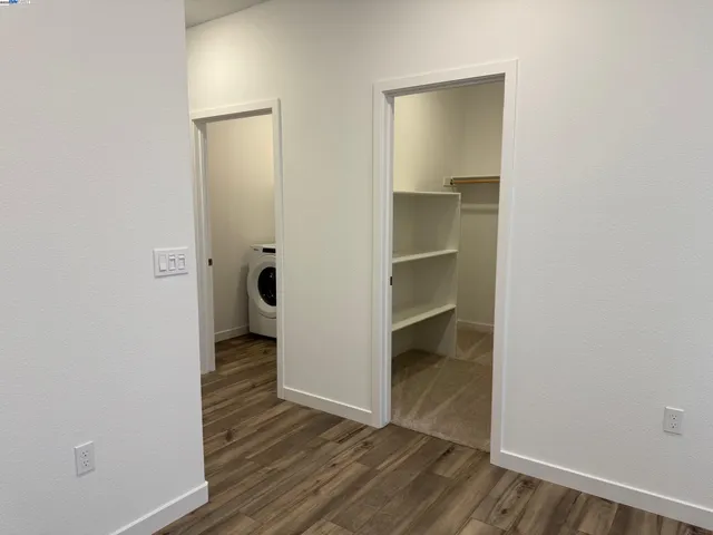a view of a hallway with wooden floor and closet
