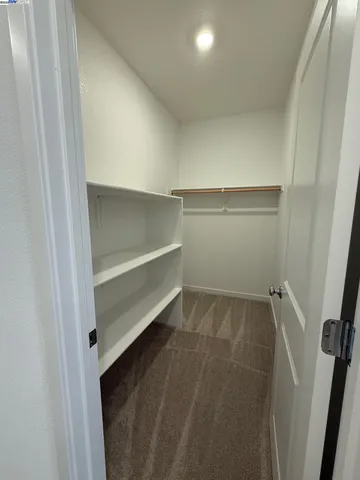 a view of walk in closet with empty racks