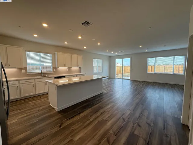 a large kitchen with stainless steel appliances granite countertop a large counter top a sink and a dishwasher