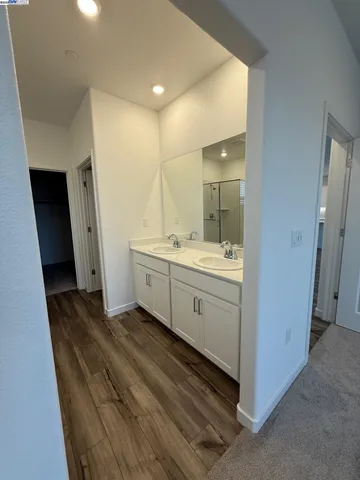 a spacious bathroom with a double vanity sink a mirror and a shower