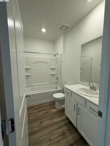 a bathroom with a granite countertop sink toilet a shower and a mirror