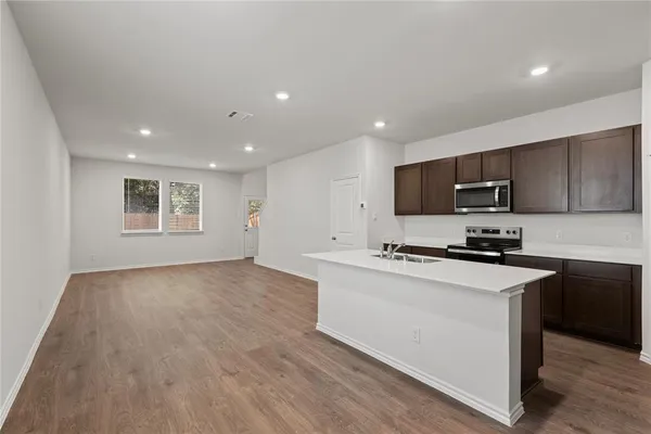 a kitchen with stainless steel appliances granite countertop a stove a sink and a refrigerator
