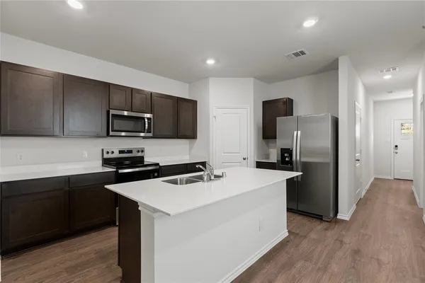 a kitchen with a refrigerator stove microwave and sink