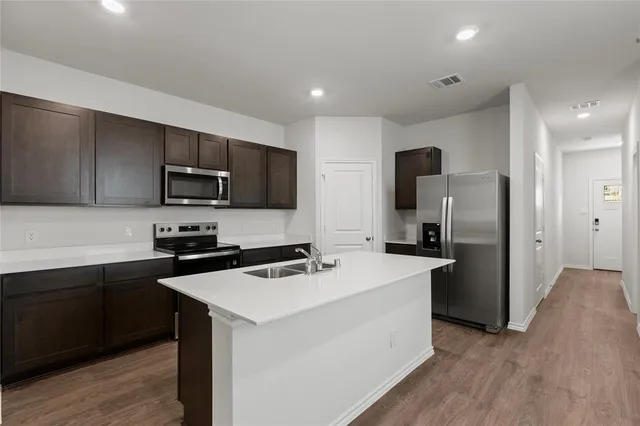 a kitchen with a refrigerator stove microwave and sink