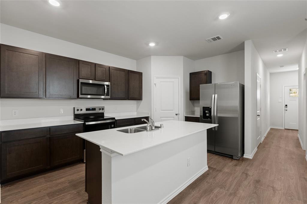 7016 Vining Drive Princeton, TX 75407 - Photo 4 of 22 a kitchen with a refrigerator stove microwave and sink