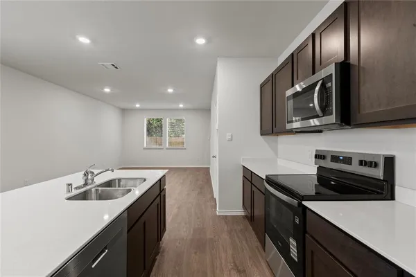 a kitchen with granite countertop stainless steel appliances sink stove microwave and refrigerator