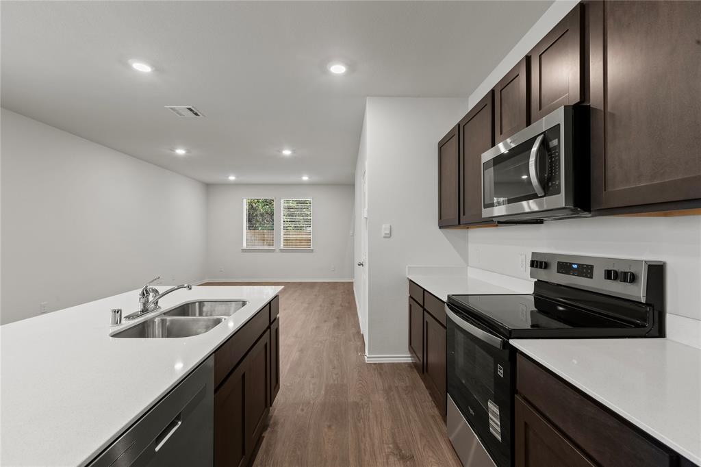 7016 Vining Drive Princeton, TX 75407 - Photo 5 of 22 a kitchen with granite countertop stainless steel appliances sink stove microwave and refrigerator