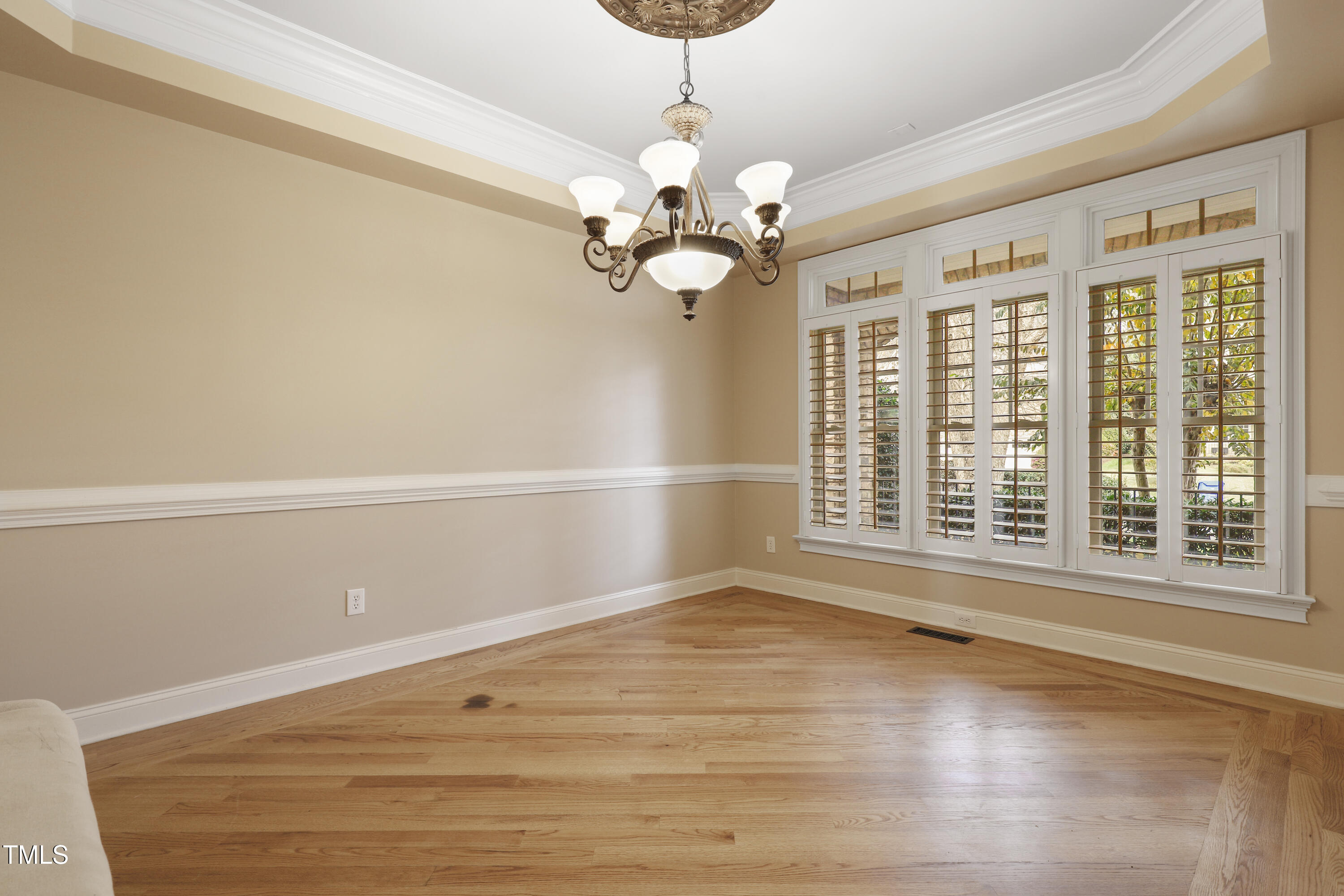 12309 Beestone Lane Raleigh, NC 27614 - Photo 7 of 73 a view of an empty room with a window and wooden floor