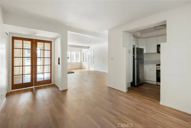 a view of a big room with wooden floor and a kitchen