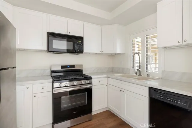 a kitchen with white cabinets and stainless steel appliances