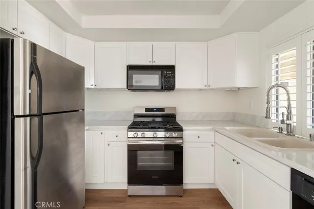 a kitchen with stainless steel appliances a stove a sink and a refrigerator