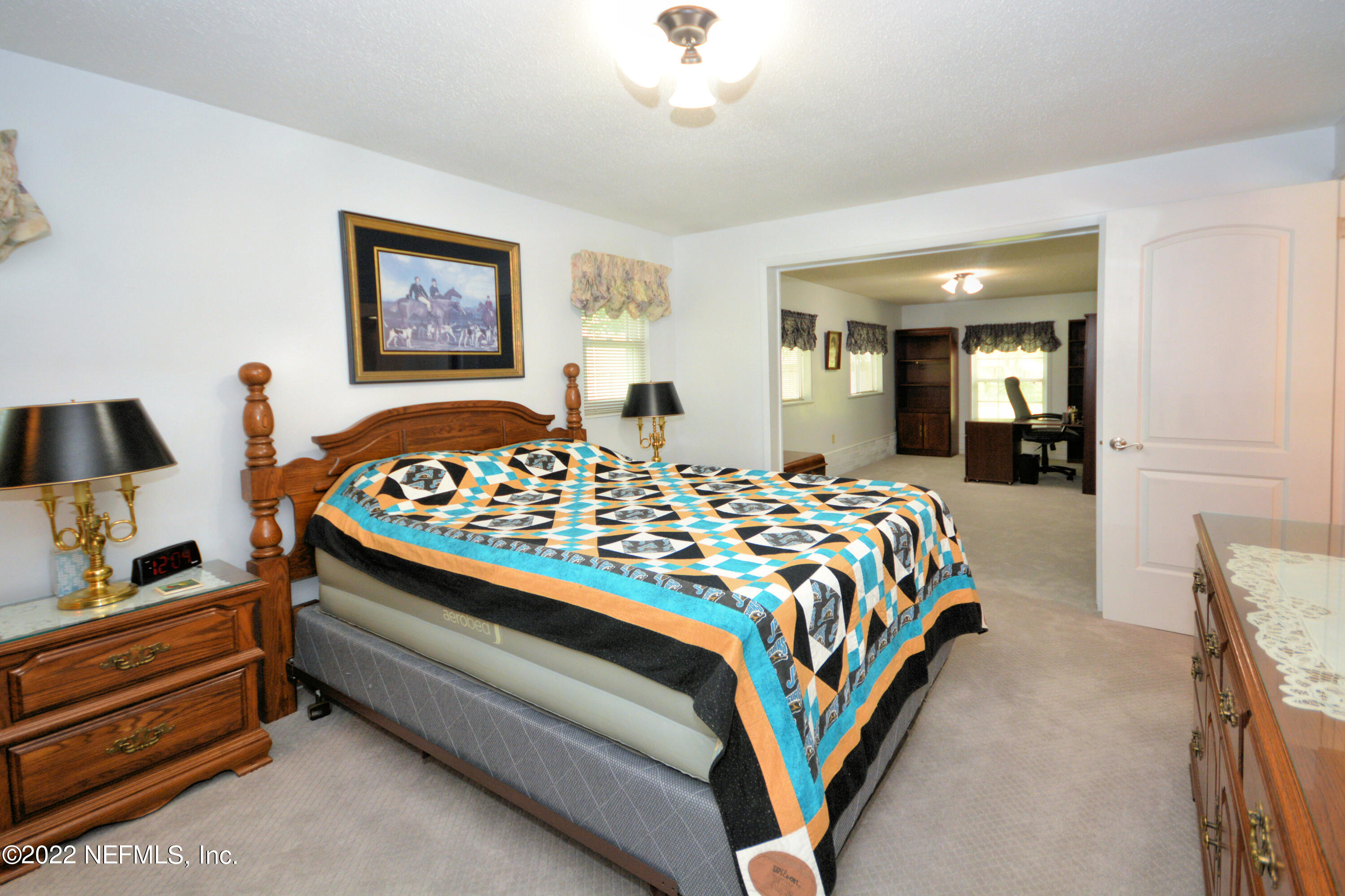 2282 Marcel Drive Orange Park, FL 32073 - Photo 16 of 29 a bedroom with a bed and a chandelier