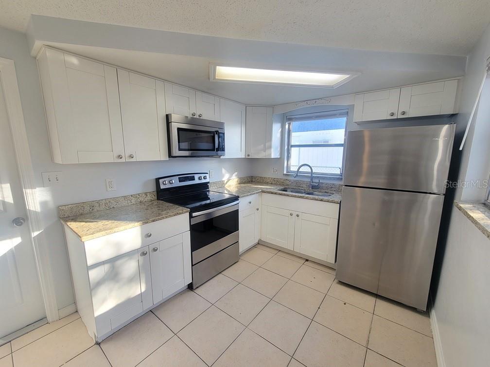 1415 Wickham Lane Holiday, FL 34691 - Photo 6 of 17 a kitchen with a refrigerator sink and microwave