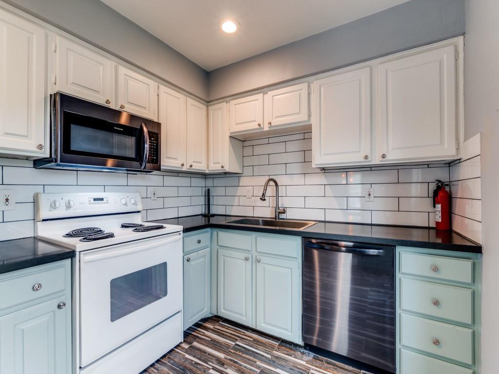 5407 Bryan Street, Unit B209 Dallas, TX 75206 - Photo 13 of 25 a kitchen with cabinets stainless steel appliances a sink and a microwave