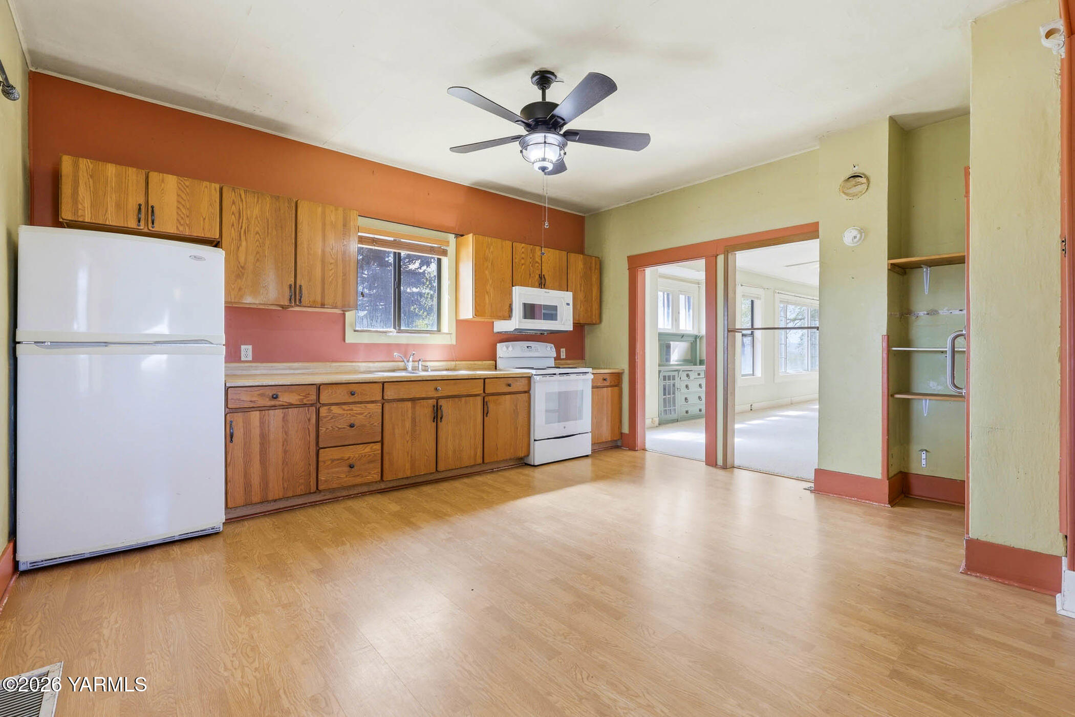 721 Blaine Road Granger, WA 98932 - Photo 8 of 45 a large white kitchen with a refrigerator a sink dishwasher a stove and a refrigerator with wooden floor