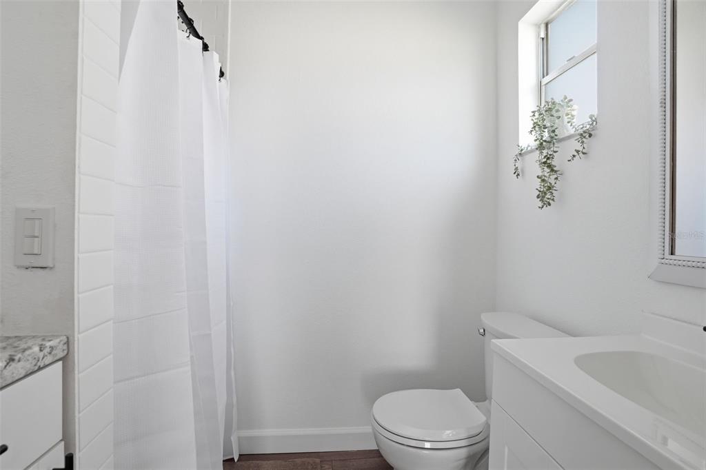 2076 Landover Boulevard Spring Hill, FL 34608 - Photo 12 of 37 a white toilet sitting next to a white sink and vanity