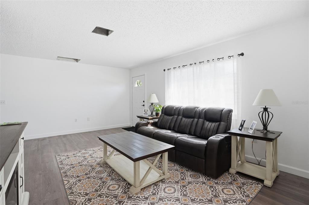 2076 Landover Boulevard Spring Hill, FL 34608 - Photo 14 of 37 a living room with furniture a rug and wooden floor