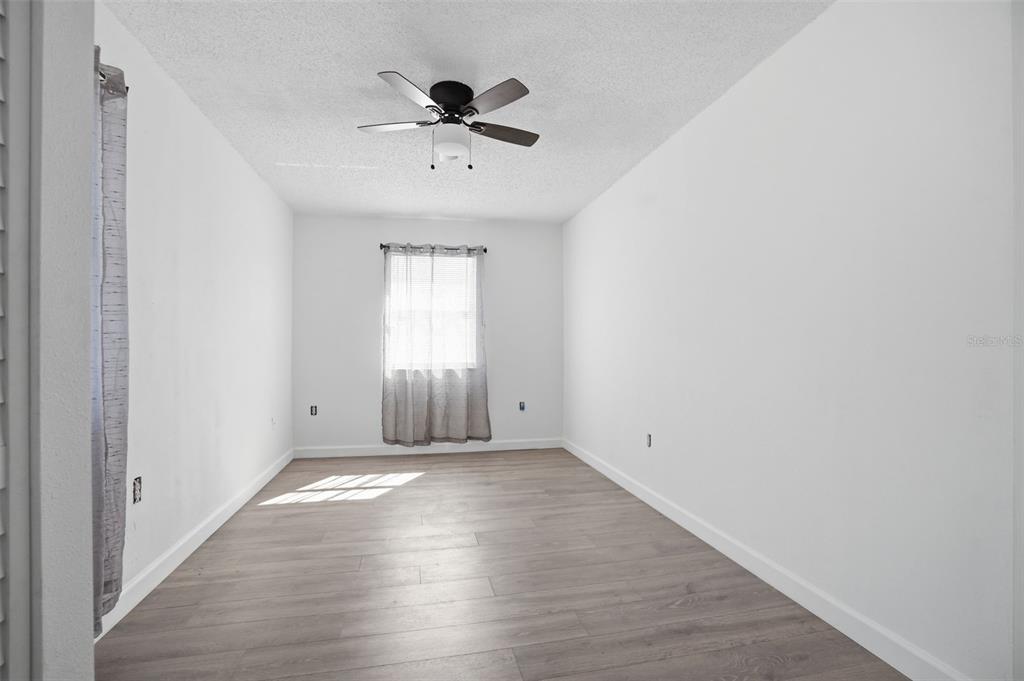 2076 Landover Boulevard Spring Hill, FL 34608 - Photo 20 of 37 wooden floor in an empty room with a window
