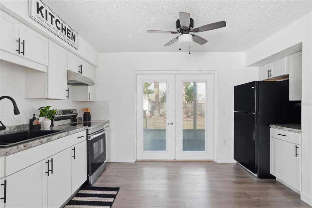 2076 Landover Boulevard Spring Hill, FL 34608 - Photo 2 of 37 a kitchen with stainless steel appliances a sink a stove a refrigerator cabinets and a dining table
