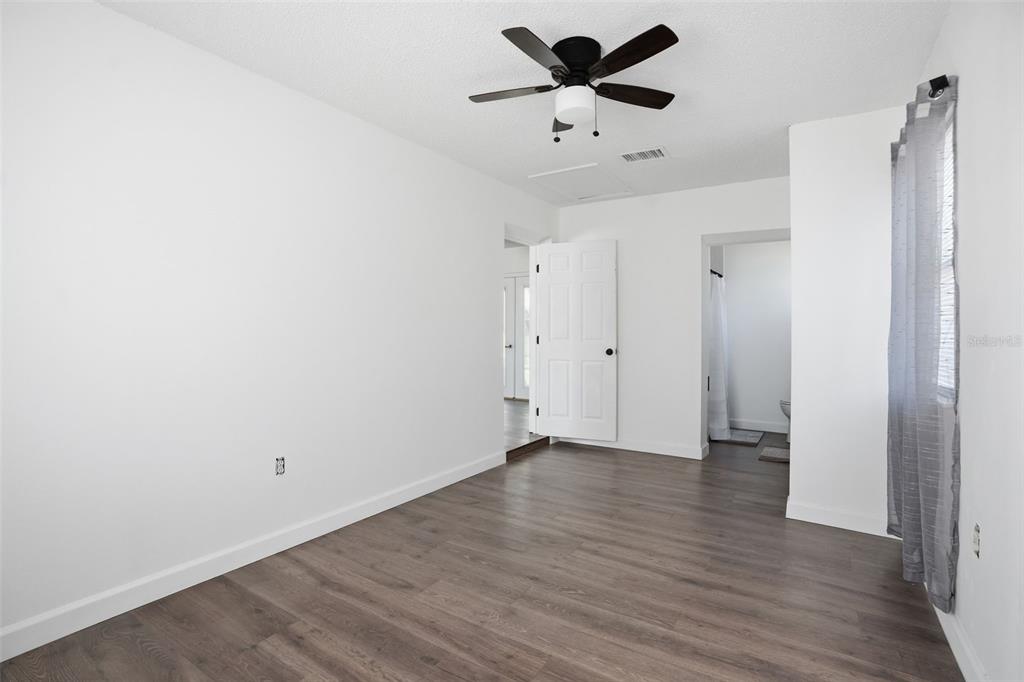 2076 Landover Boulevard Spring Hill, FL 34608 - Photo 21 of 37 an empty room with wooden floor and ceiling fan
