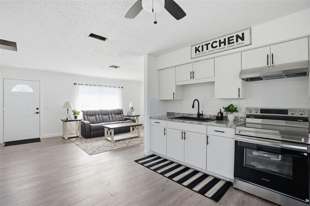 2076 Landover Boulevard Spring Hill, FL 34608 - Photo 3 of 37 a kitchen with stainless steel appliances a stove and white cabinets