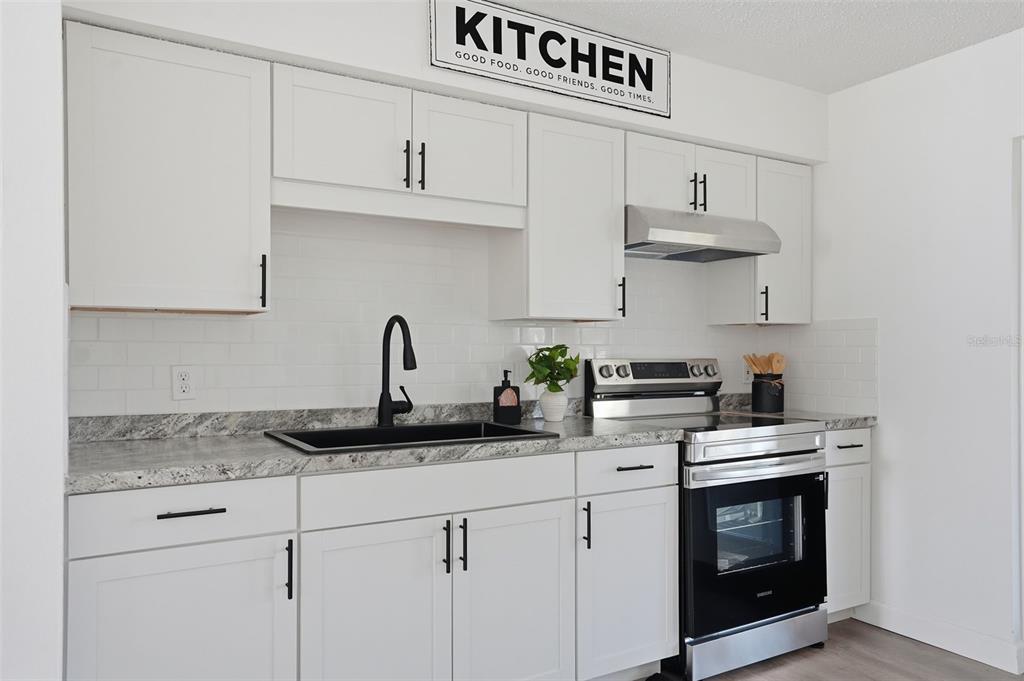 2076 Landover Boulevard Spring Hill, FL 34608 - Photo 4 of 37 a kitchen with stainless steel appliances granite countertop a sink a stove and cabinets