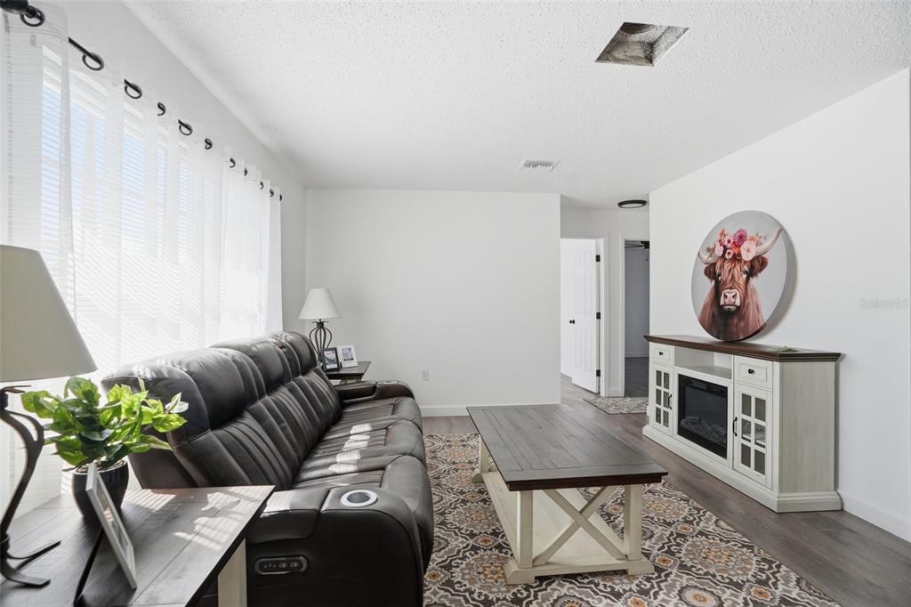 2076 Landover Boulevard Spring Hill, FL 34608 - Photo 7 of 37 a living room with furniture a rug and a fireplace