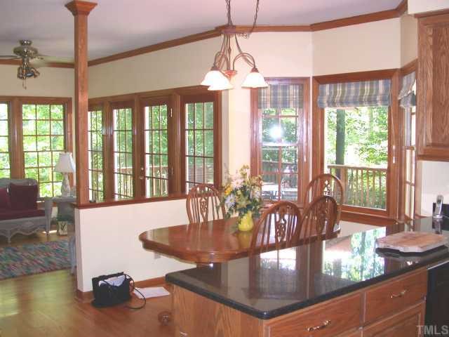 5120 Celbridge Place Raleigh, NC 27613 - Photo 3 of 12 a dining room with furniture a chandelier and wooden floor