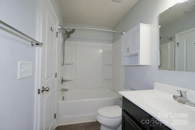 a bathroom with a sink toilet vanity and shower