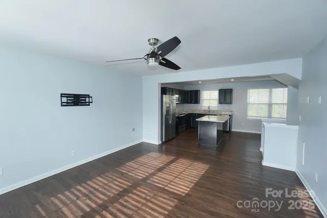 a view of a kitchen with a sink and dishwasher with wooden floor