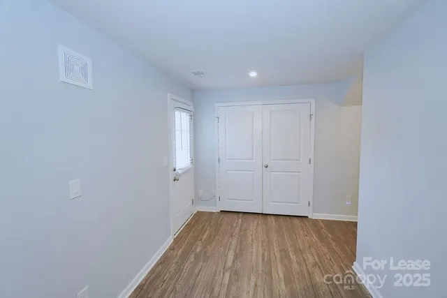 a view of a room with wooden floor and white walls