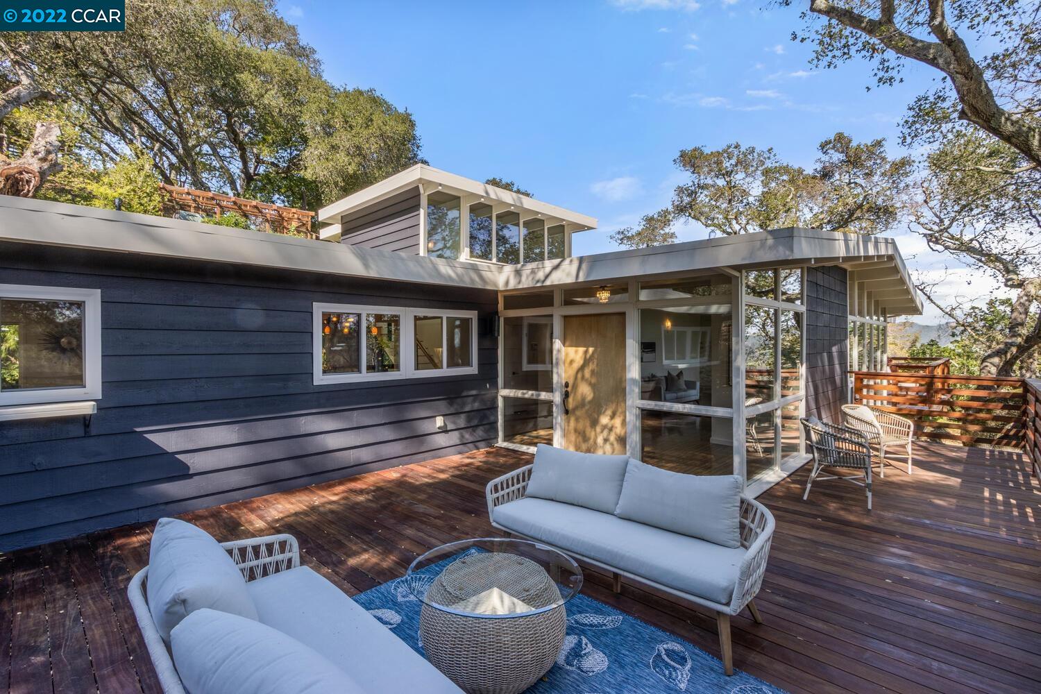 a view of a patio with couches and a table and chairs with wooden floor