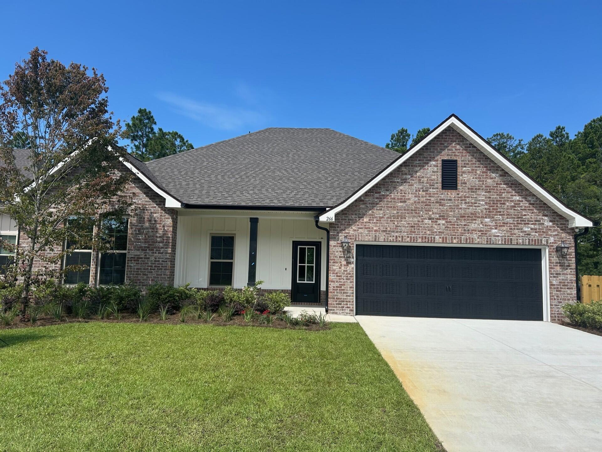 266 Constellation Avenue Freeport, FL 32439 - Photo 1 of 3 a front view of house with yard and trees in the background