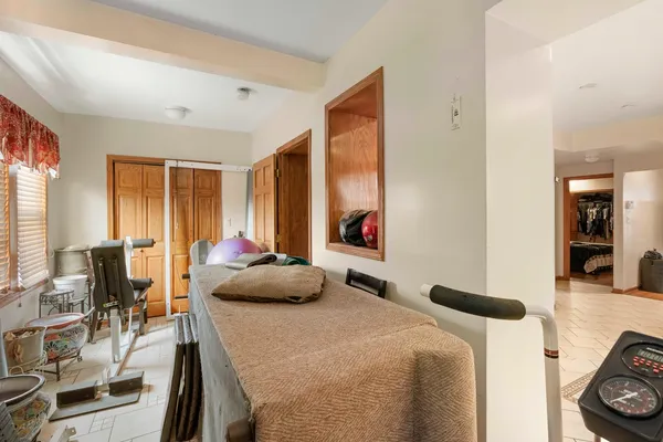 a bedroom with a bed and a table in it with window