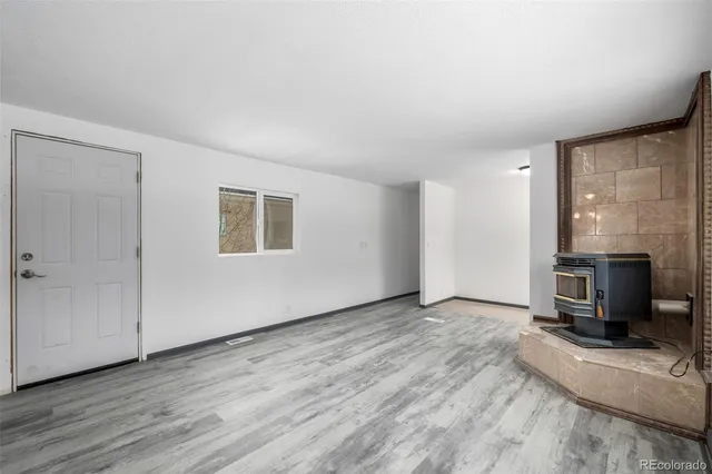wooden floor fireplace and windows in an empty room