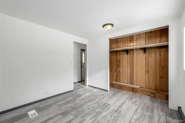 an empty room with wooden floor and closet