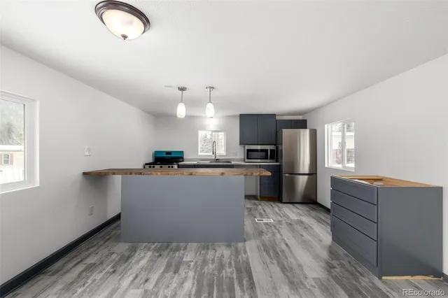a kitchen with a refrigerator and a stove top oven