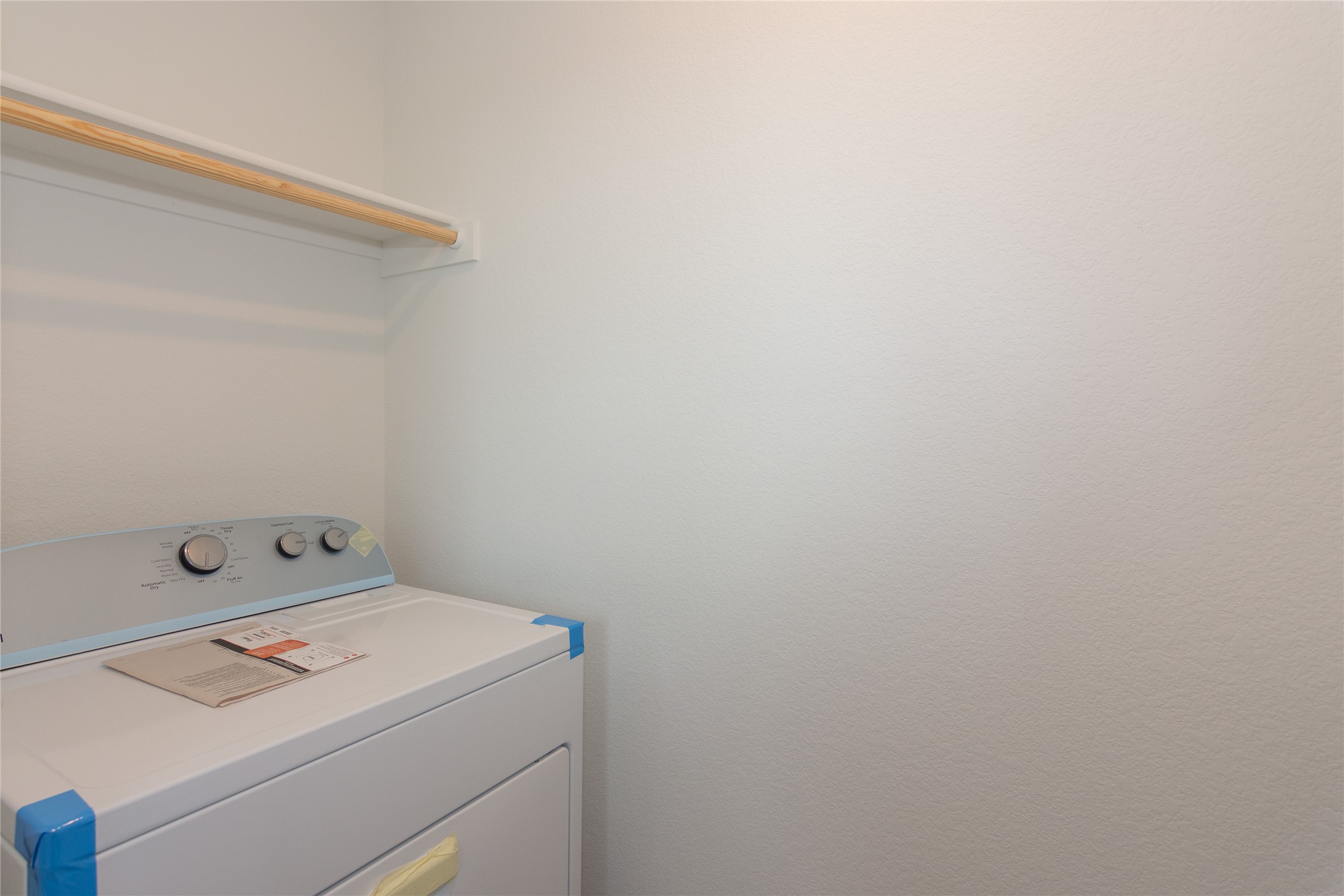 153 Star Packer Lane Jarrell, TX 76537 - Photo 20 of 30 A well-organized laundry area featuring a convenient hanging rod above the appliance.