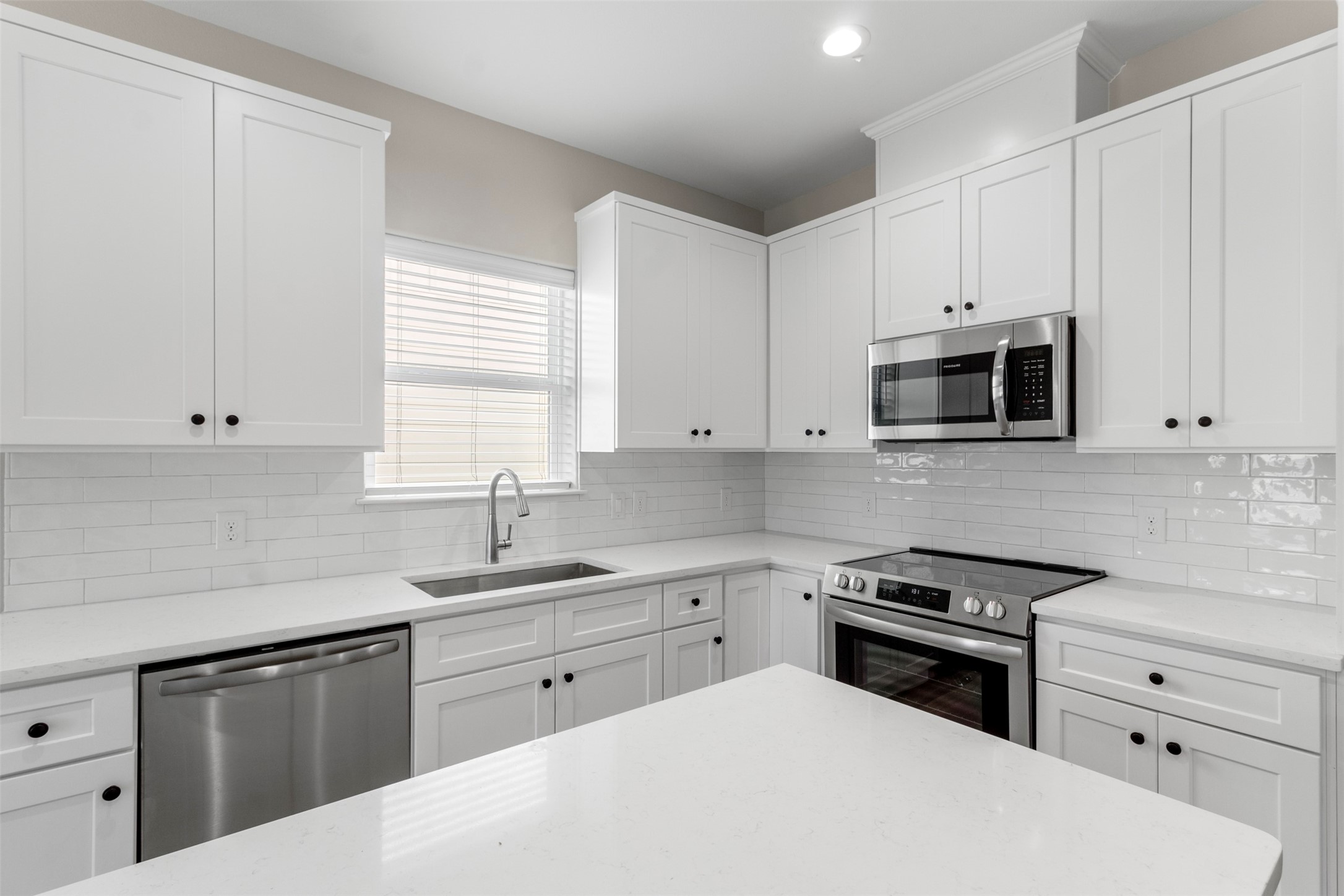 3150 South Cleveland Street Dayton, TX 77535 - Photo 4 of 24 a kitchen with white cabinets and stainless steel appliances