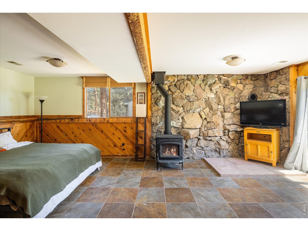 201 Wild Tiger Road Boulder, CO 80302 - Photo 27 of 43 lower-level family room featuring natural stone and wood accents