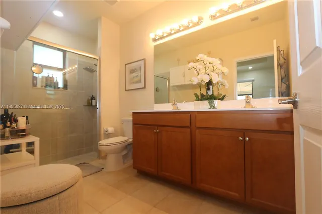 a bathroom with a double vanity sink toilet and a mirror