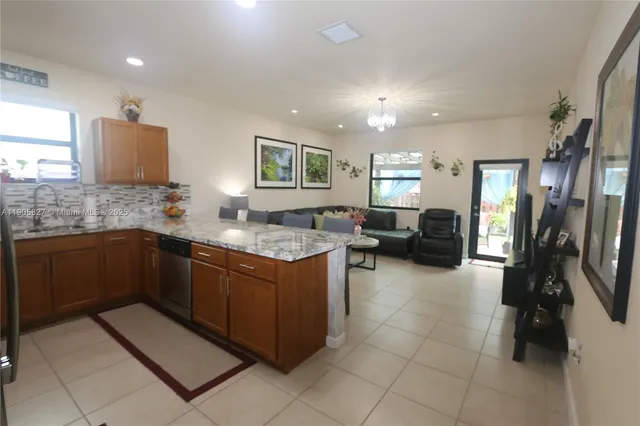 a kitchen with granite countertop a sink stove and cabinets