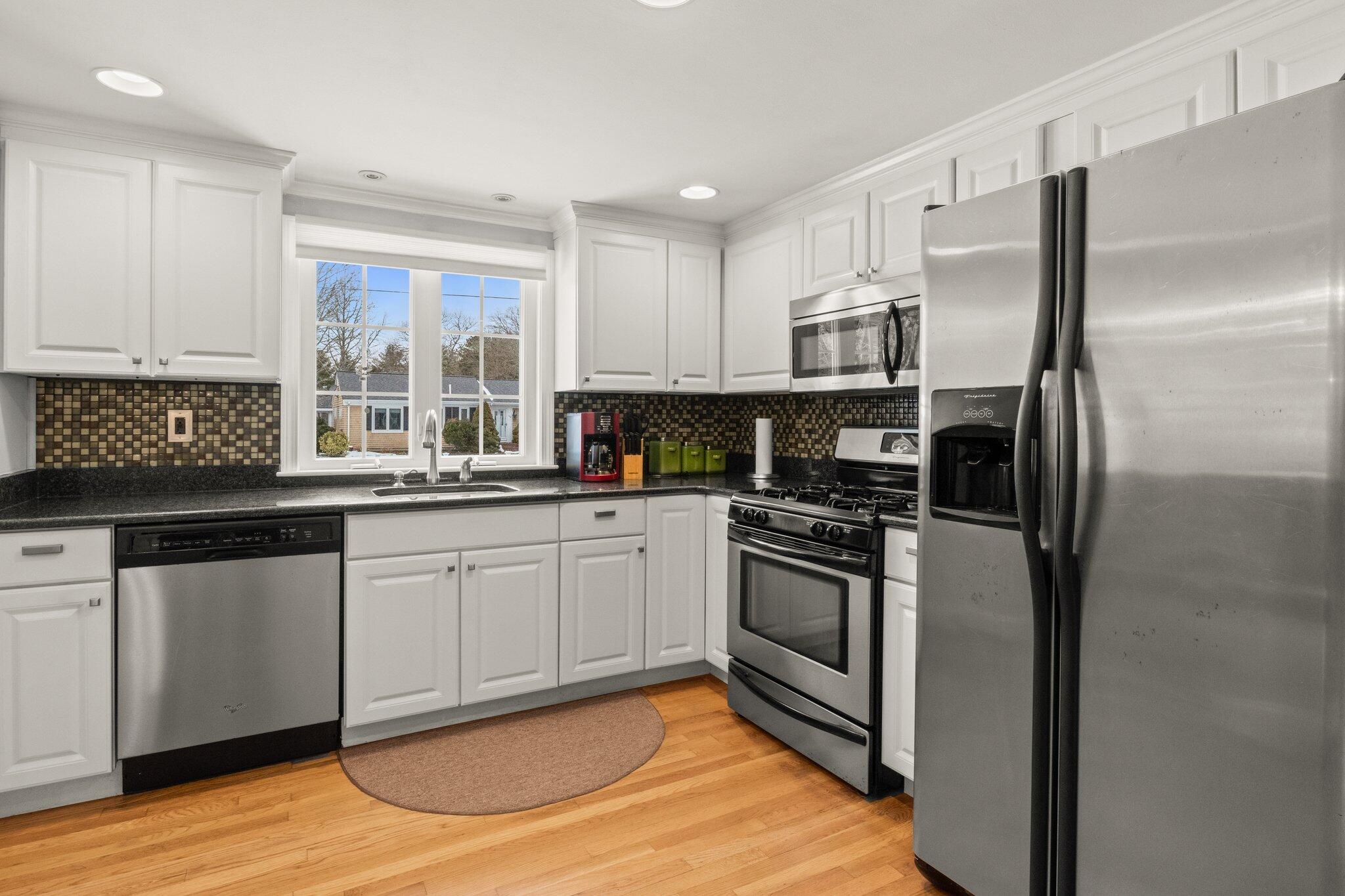 156 Sheaffer Road Centerville, MA 02632 - Photo 4 of 32 a kitchen with stainless steel appliances granite countertop a stove a sink and a refrigerator