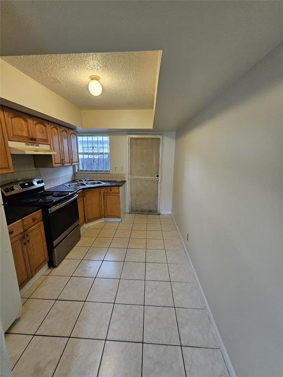 716 Southwest 7th Street, Unit 1 Dania Beach, FL 33004 - Photo 7 of 15 a kitchen with a sink a stove top oven and cabinetry