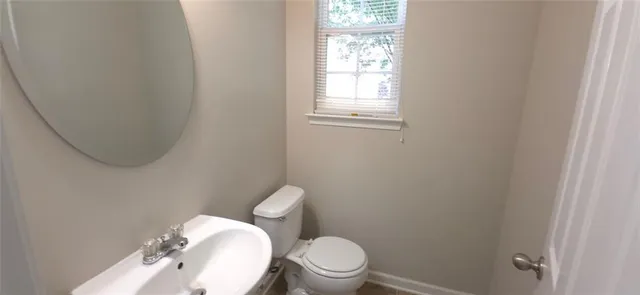 a white toilet sitting next to a bathroom sink and vanity