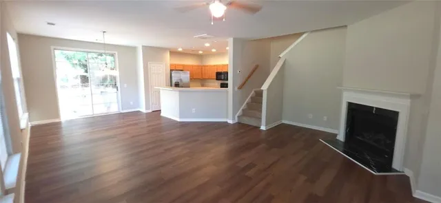a view of empty room with wooden floor and fireplace