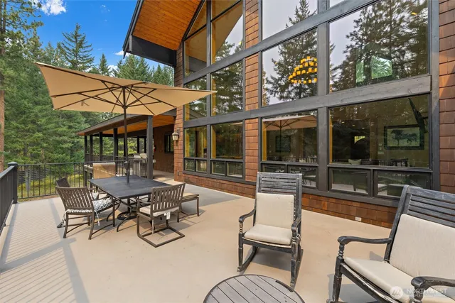 a view of a patio with table and chairs potted plants with wooden floor and fence